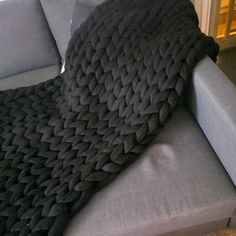 a gray couch with a black blanket on it