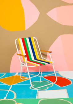 a multicolored chair sitting in front of a colorful wall