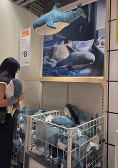 a woman holding a stuffed animal in front of a display