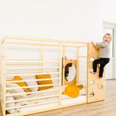 a toddler climbing up the side of a bunk bed in a room with white walls