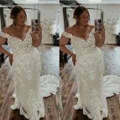 a woman taking a selfie while wearing a wedding dress with off the shoulder sleeves