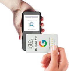 a person holding up a credit card in front of an iphone with the app on it