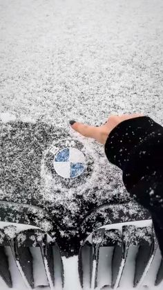 someone is touching the snow on their car