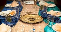 the table is set with blue and white plates, silverware, and napkins