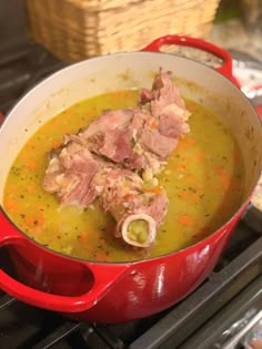 a red pot filled with soup sitting on top of a stove