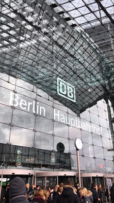 people are standing in front of a glass building with the words berlin hauptlanner on it