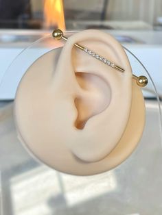 a pair of ear piercings sitting on top of a glass table next to a fire