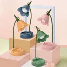 three flower shaped vases on display in front of a pink background with the words forest lamp