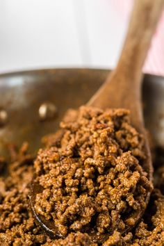 a wooden spoon filled with food on top of a pan