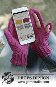 a person wearing pink gloves holding up a cell phone