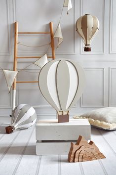 an assortment of hot air balloons are on display in a room with white walls and flooring