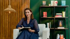 a woman sitting in a chair reading a book