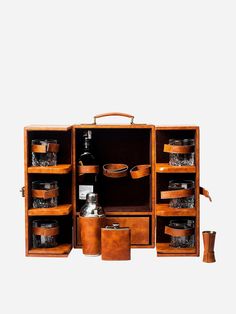 an open wooden cabinet with pots and pans on it's shelves, in front of a white background