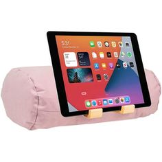 an ipad is sitting on top of a pillow with a wooden holder attached to it