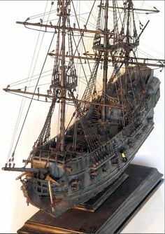 a model ship is shown on a wooden stand