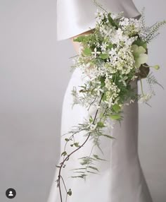 a bridal gown with white flowers and greenery