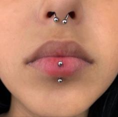 a woman's nose has three piercings on it