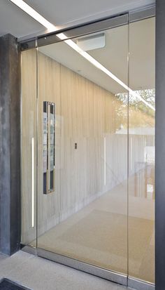 an empty room with glass walls and sliding doors