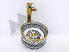 a white and gold bathroom sink sitting on top of a counter next to a faucet