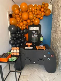 a video game themed birthday party with oranges and black balloons hanging from the ceiling