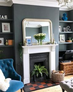 a living room filled with furniture and a fire place in front of a mirror on the wall