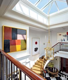 a staircase leading up to a skylight in a white room with black and yellow checkered flooring