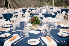 a table set up with place settings and flowers in vases on the centerpiece