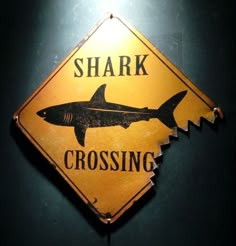 a yellow sign that says shark crossing on it