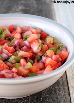 a white bowl filled with chopped vegetables on top of a wooden table