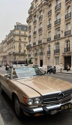 an old mercedes parked on the side of the road