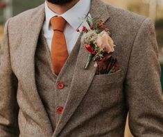 a man wearing a suit and orange tie