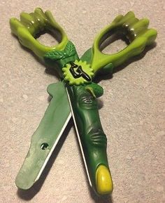 a pair of scissors with green handles are on the floor