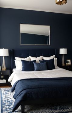 a bedroom with blue walls and white bedding