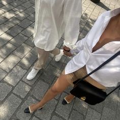 a woman sitting on the ground with her legs crossed and wearing high heeled shoes