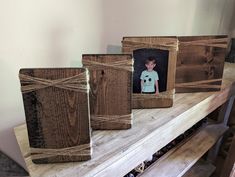 three wooden frames tied with twine on top of a table next to a shelf