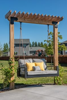 a swing chair with pillows on it in the yard