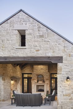 an outdoor living area with stone walls and furniture