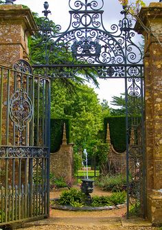 an iron gate with a fountain in the middle