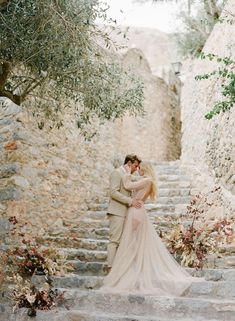 a bride and groom standing on some steps