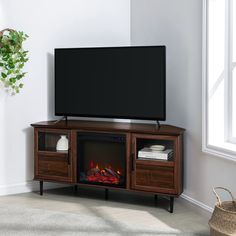 a flat screen tv sitting on top of a wooden entertainment center next to a fire place