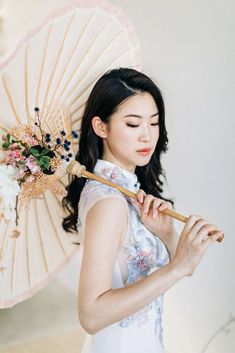 a woman in a white dress holding an umbrella