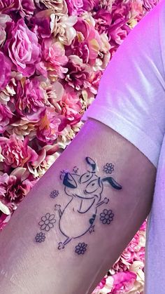 a person with a tattoo on their arm next to some pink flowers and purple petals