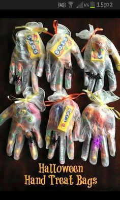 five halloween hand treat bags in the shape of hands with candy on them, all wrapped in plastic