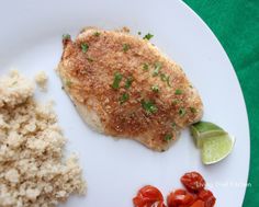 a white plate topped with meat and rice next to a slice of green leafy garnish