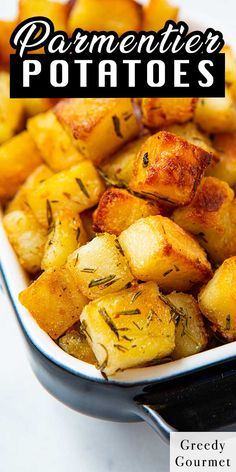 a white dish filled with potatoes on top of a table