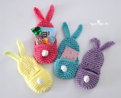 three crocheted bunny bags with candy and candies in them sitting next to each other