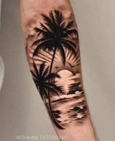 a man with a palm tree and sunset tattoo on his arm is standing in front of the ocean