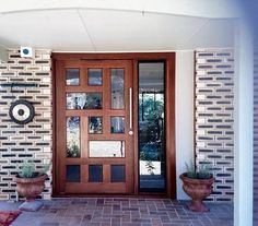 two potted plants are sitting in front of the door