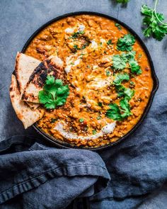 a skillet filled with food and garnished with cilantro, tortilla chips