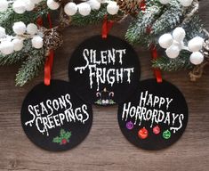 three black chalkboard ornaments with white writing on them